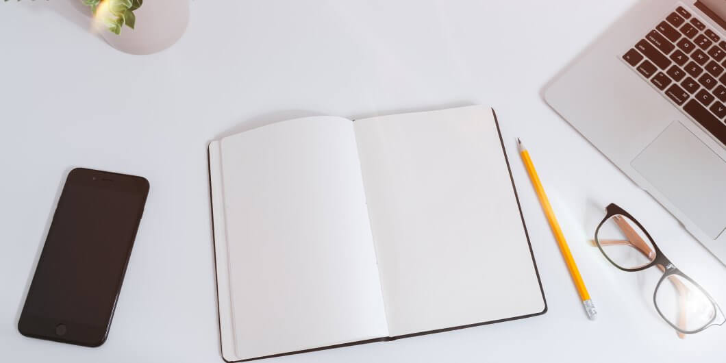 journal and phone on white table