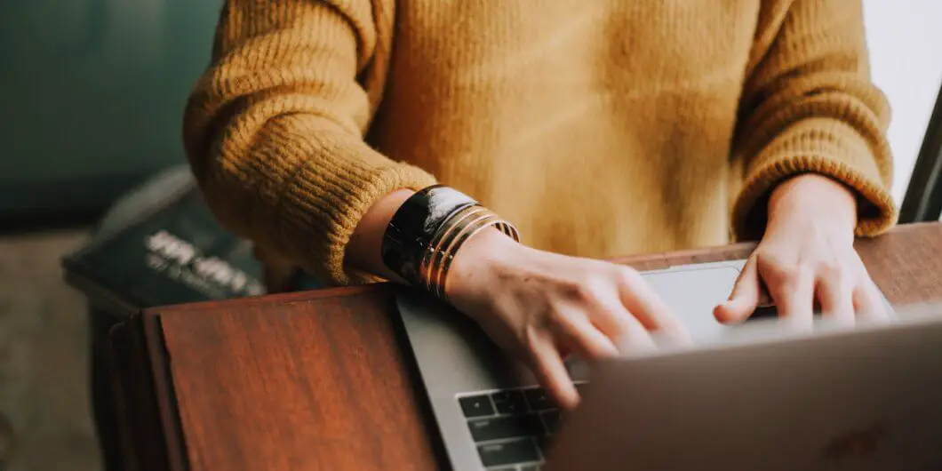 person sitting and typing on laptop